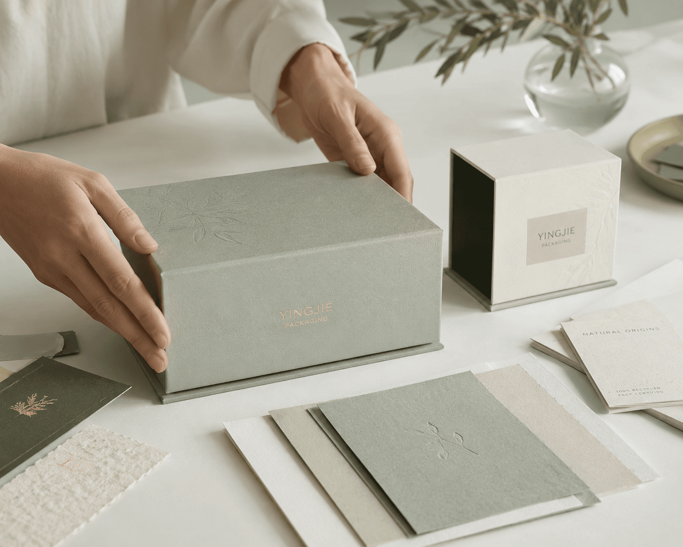 Craftsperson's hands assembling a premium rigid box at the sample table