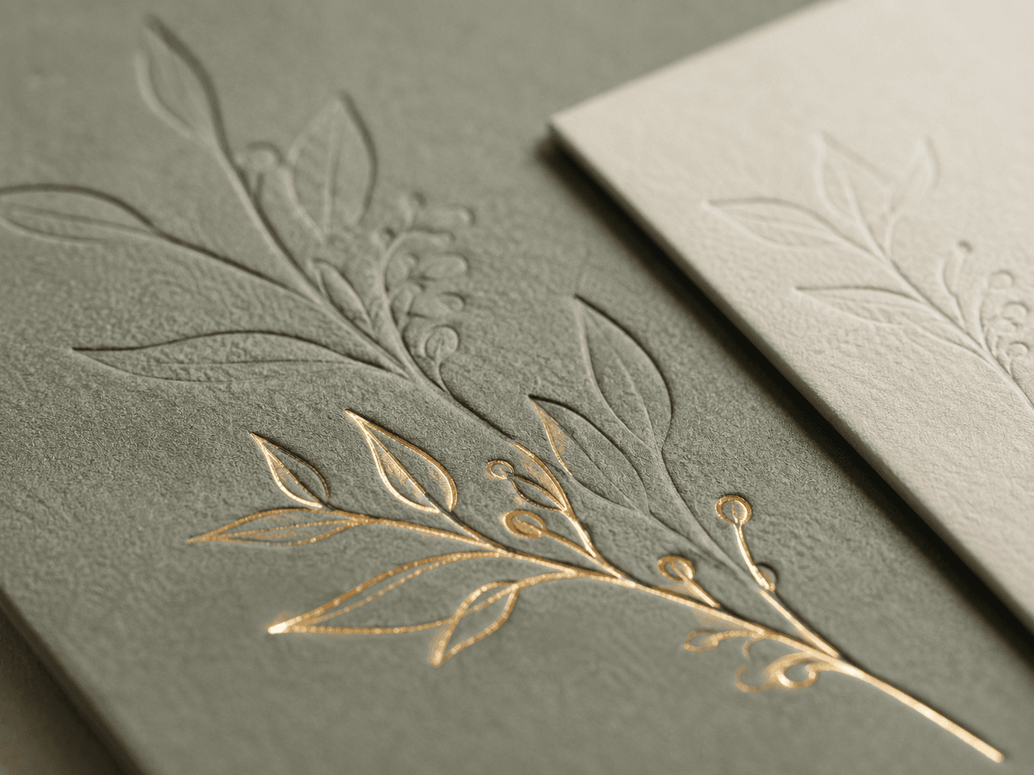 Gold foil-stamped botanical leaf with multi-level deboss on sage paper
